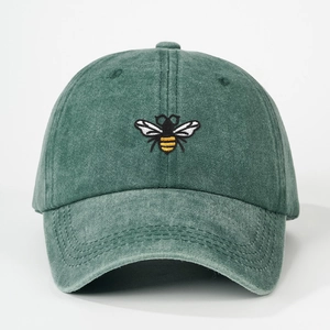 Close-up of bee embroidery detail on forest green washed cotton baseball cap