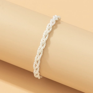 Close-up of bright silver woven chain necklace showing intricate metallic texture details