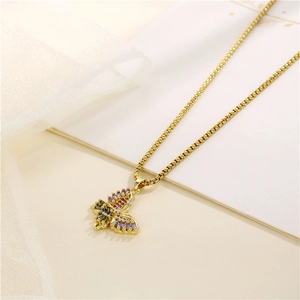 Gold butterfly necklace with colorful zircon stones on a beige background with silk ribbon