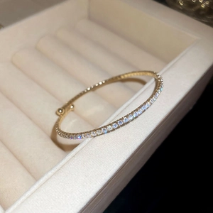 Detailed view of elegant gold-plated zircon bracelet placed in a beige velvet jewelry box