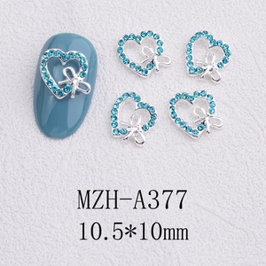 Detail of light blue heart rhinestones with silver bow for 3D nail art decoration
