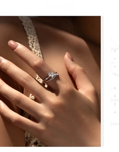 Detail of heart-shaped moissanite ring with crossing bands worn on finger