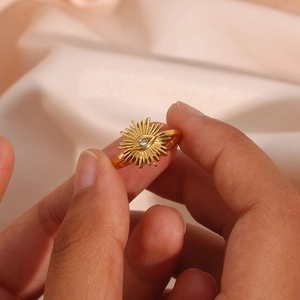 Close-up of golden 18K plated stainless steel ring with zircon evil eye and sunburst
