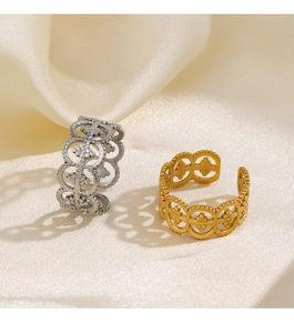 Detailed view of hollow cutout gold and silver rings on silk background showing fine texture