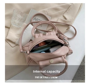 Detailed view of the pink pleated bag's spacious interior with secure zipper and magnetic snap