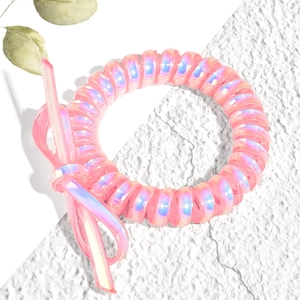 Gros plan d'un élastique spirale rose irisé avec un détail de nœud en plastique assorti