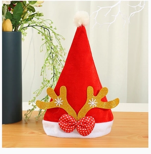 Close-up of velvet Santa hat with gold glitter antlers and red polka dot bow decoration