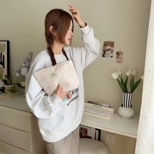 Corduroy cream makeup bag shown in a cozy home setting with vintage aesthetic details