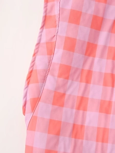 Close-up of pink and orange plaid pattern fabric with side seam stitching details
