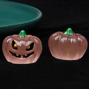 Detailed macro view of 3D luminous resin pumpkin figurines with jack-o'-lantern faces