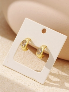 Close-up of gold C-shaped S925 silver earrings featuring a clear round zircon stone
