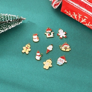 Vue détaillée de neuf breloques de Noël en émail coloré sur un fond vert festif