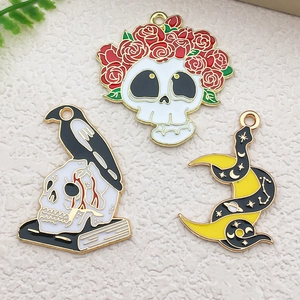 Gothic enamel charms featuring skull with rose, raven on books, and serpent with moon