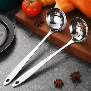 Polished stainless steel soup ladle and slotted spoon set with long handles on a dark counter