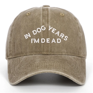 Détail de la broderie blanche 'IN DOG YEARS I'M DEAD' sur la casquette en coton délavé