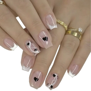 Short square press-on nails with French white tips and black heart stripe patterns