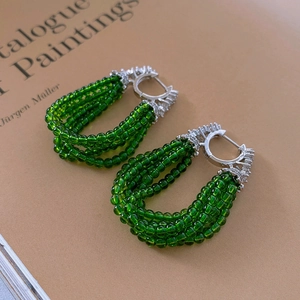 Gros plan de boucles d'oreilles en perles vertes avec boucle en argent sertie de zircon