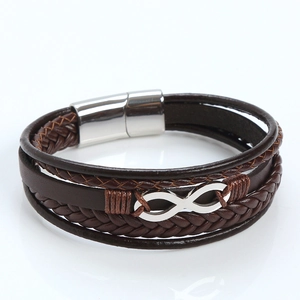 Macro detail of braided brown leather bracelet with silver infinity charm and magnetic clasp