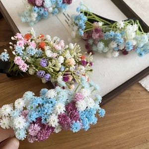 Detailed view of colorful acrylic flower hair clips on a white wooden decorative frame