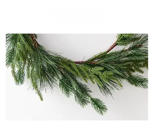 Detailed close-up of lush artificial pine needles and brown wood base of a Christmas wreath