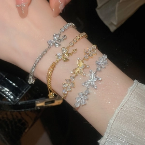 Close-up of layered 18k gold plated butterfly bracelets with sparkling zircon stones