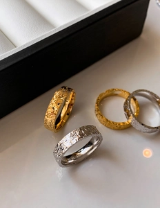 Detailed macro view of 18k gold plated rings featuring unique hammered texture and stamps