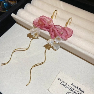 Detail of pink fabric flower earrings with white lily buds and golden wavy tassels