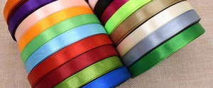 Macro shot of 1cm satin ribbon rolls in multiple colors for gift wrapping and DIY crafts