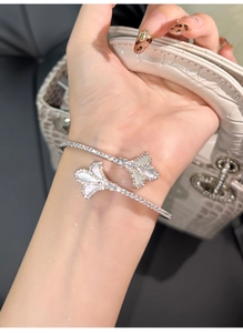 Detail of silver iris-shaped open bangle with white mother of pearl and zircon settings
