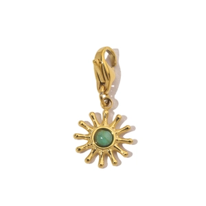 Detailed view of sun-shaped gold pendant with green stone and lobster clasp