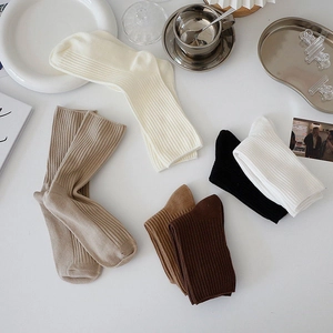 Minimalist knit crew socks with vertical ribbing in assorted solid neutral colors