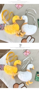Detail of plush goose crossbody bags in white and yellow with plaid scarves and straps