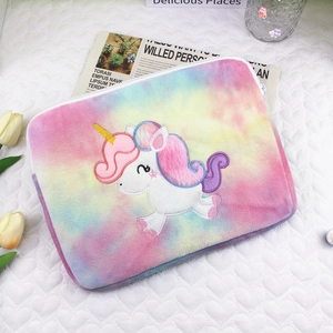 Detail of unicorn embroidery and rainbow tie-dye plush texture on a soft tablet sleeve
