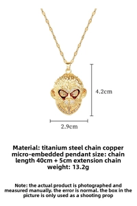 Macro detail of gold-plated monkey king pendant featuring pavé crystals and red accents