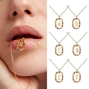 Detail view of gold necklaces with colorful zircon stones and customizable initials
