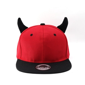 Détail de la casquette snapback rouge avec cornes de diable noires et étiquette argentée