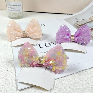 Close-up of sparkling sequin mesh bow hair clips in pink, purple and rainbow colors