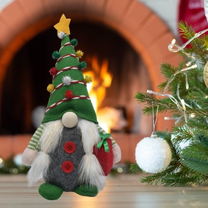 Détail d'un gnome de Noël artisanal avec pompons festifs devant une cheminée chaleureuse