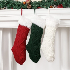 Détails de chaussettes de Noël en tricot torsadé suspendues sur la cheminée