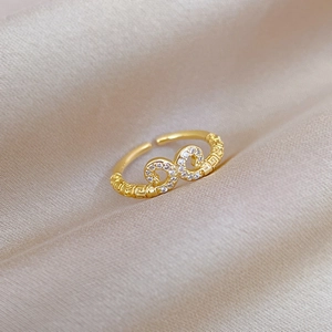 Macro shot of gold adjustable ring featuring pavé zircons and Greek key relief patterns