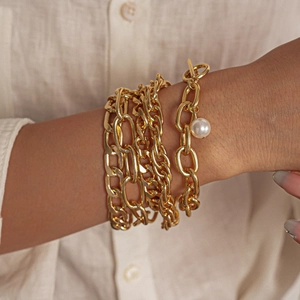5-piece gold layering bracelet set with geometric metal chains and a white pearl pendant