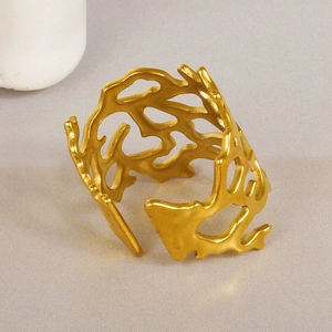 Macro detail of a golden irregular hollow bracelet with organic coral branch design
