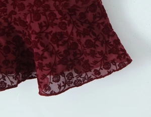 Detail of burgundy mesh fabric with elegant rose flocking and velvet texture
