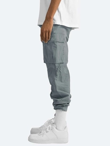 Detail view of large side utility pocket on grey cargo pants with durable cotton fabric