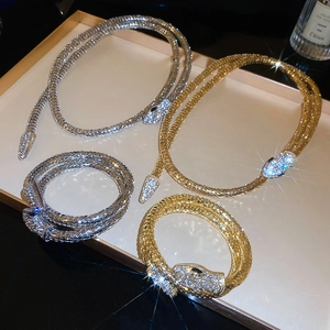 Detail of snake-shaped necklace and bracelet sets with sparkling rhinestones in gold and silver