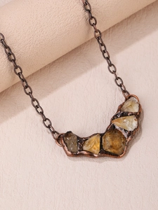 Macro shot of vintage copper necklace featuring irregular raw amethyst and citrine stones