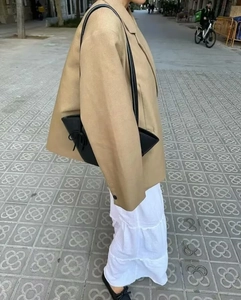 Street style view of oversized khaki blazer with side slits and layered white skirt
