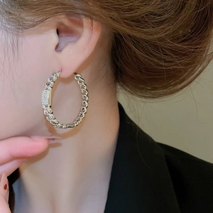 Detailed view of 18k silver plated chain-link hoop earring with pave zircon stones on model