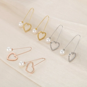 Detail of heart-shaped pearl brooches in gold, silver, and rose gold with rhinestones