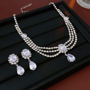 Detailed view of silver teardrop zircon necklace and earrings on a black display tray